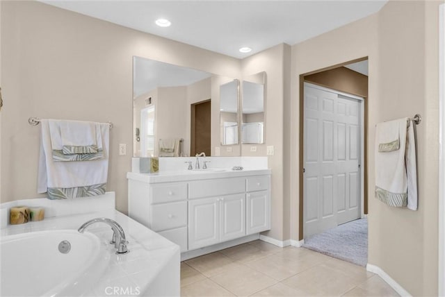 bathroom with tile patterned flooring, a bathtub, and vanity