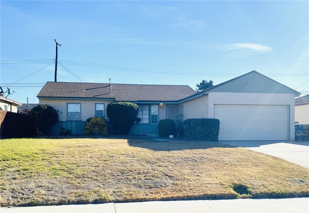 ranch-style home with a front lawn and a garage