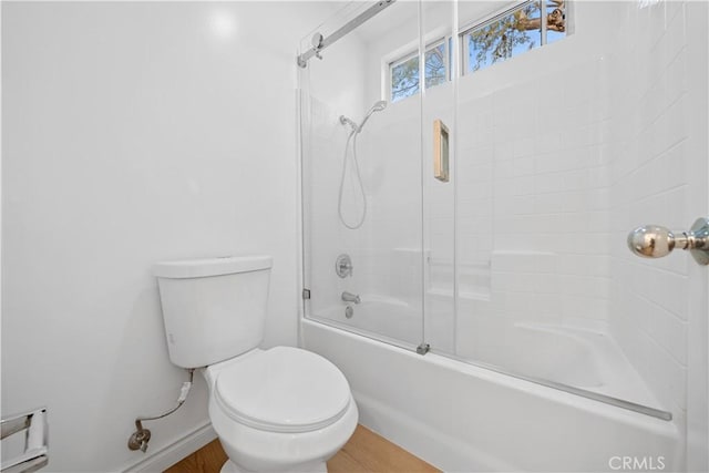 bathroom featuring toilet and enclosed tub / shower combo