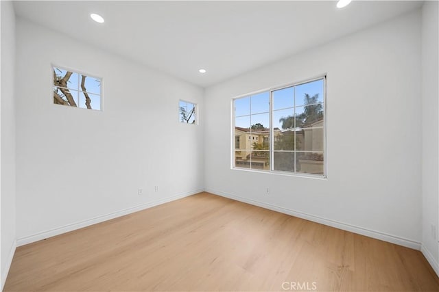 spare room featuring a wealth of natural light and light hardwood / wood-style flooring