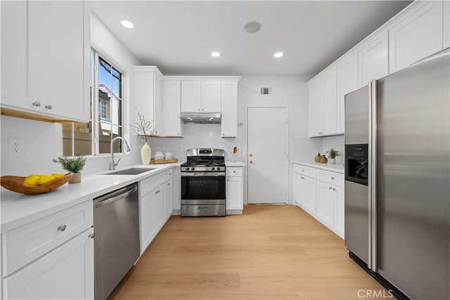 kitchen featuring light hardwood / wood-style floors, sink, white cabinetry, and stainless steel appliances