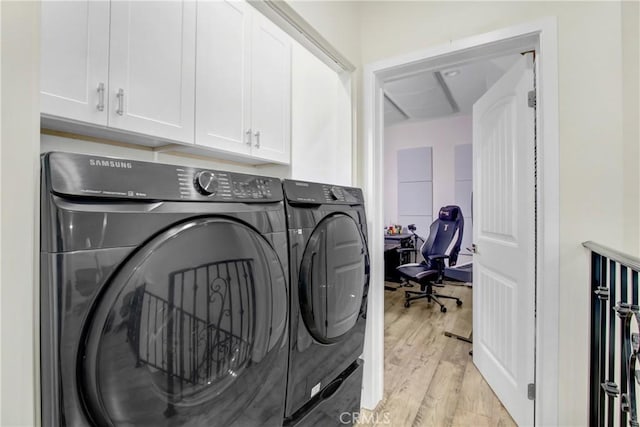 laundry room with cabinets, light hardwood / wood-style flooring, and washing machine and clothes dryer