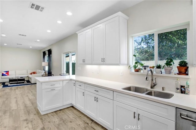 kitchen with light hardwood / wood-style flooring, dishwasher, white cabinets, and sink