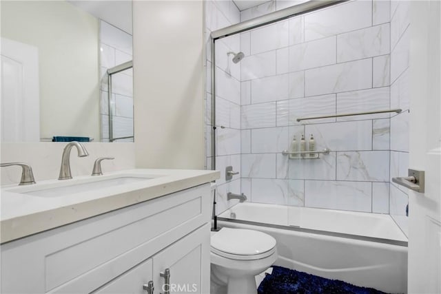 full bathroom with combined bath / shower with glass door, vanity, and toilet