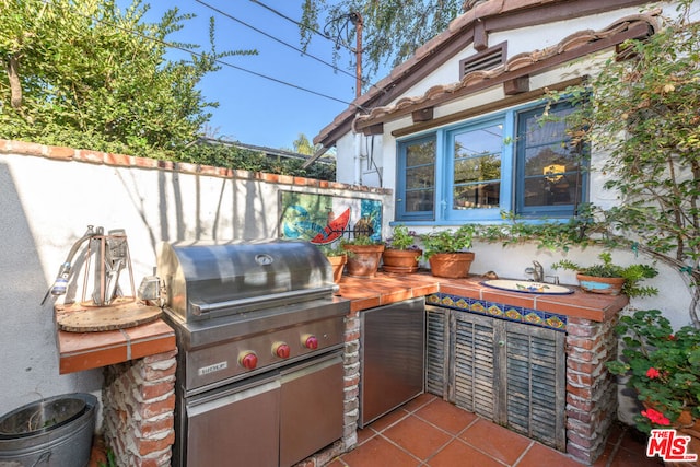 view of patio / terrace with exterior kitchen, sink, and a grill