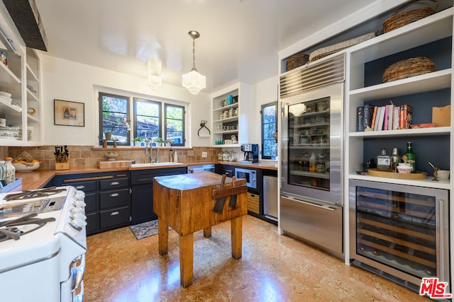 kitchen with white range with gas cooktop, wine cooler, sink, hanging light fixtures, and backsplash