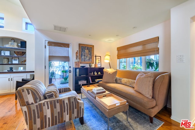 living room featuring light hardwood / wood-style floors and built in features