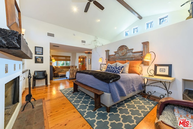 bedroom with ceiling fan, high vaulted ceiling, beamed ceiling, and hardwood / wood-style floors