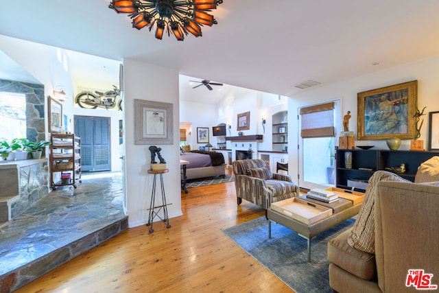 living room featuring ceiling fan, wood-type flooring, and vaulted ceiling