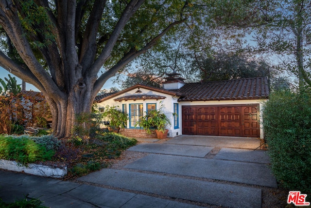 mediterranean / spanish-style home with a garage