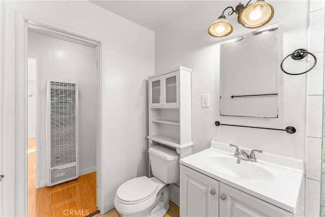 bathroom featuring toilet, vanity, and hardwood / wood-style flooring