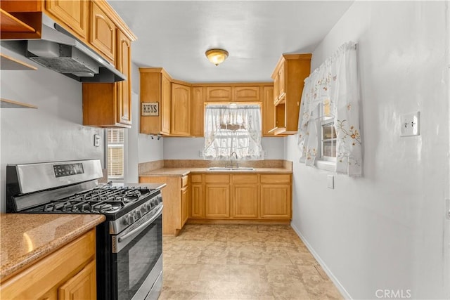 kitchen featuring light stone countertops, sink, light brown cabinets, and stainless steel gas range