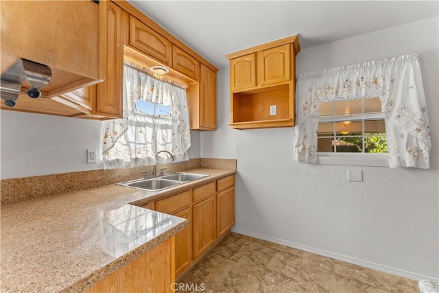 kitchen featuring light stone counters and sink