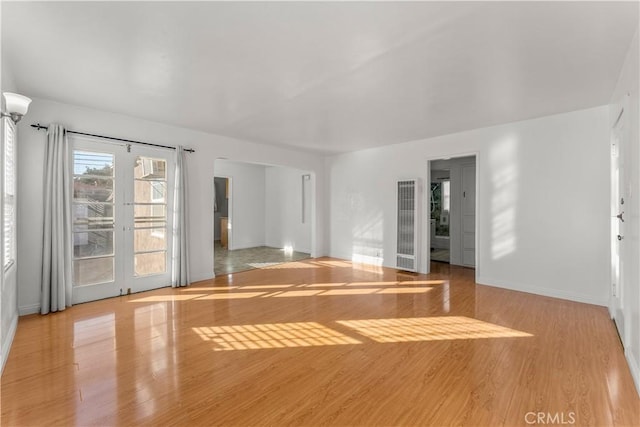 empty room featuring light wood-type flooring and french doors