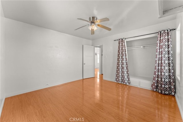 unfurnished bedroom featuring ceiling fan, light hardwood / wood-style floors, and a closet