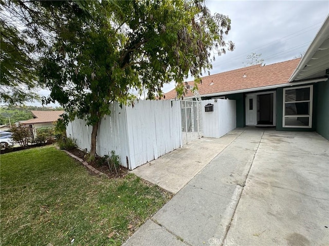 view of side of property with a yard and a patio area