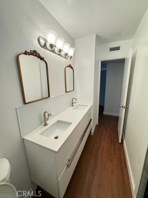 bathroom featuring vanity, toilet, and hardwood / wood-style floors