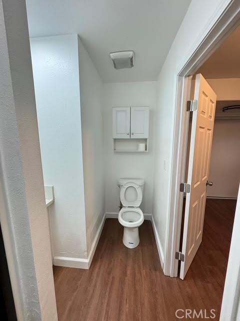 bathroom featuring hardwood / wood-style flooring and toilet