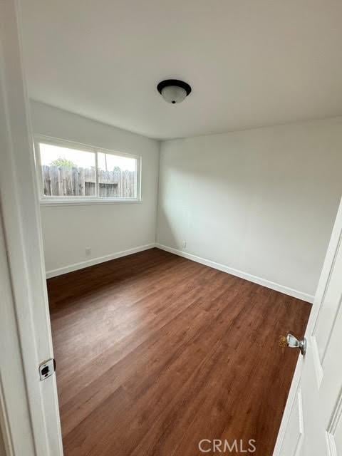 empty room with dark hardwood / wood-style flooring