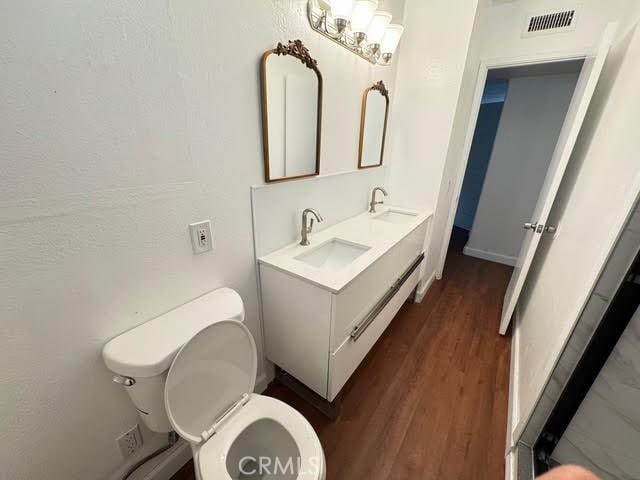 bathroom with vanity, hardwood / wood-style flooring, and toilet