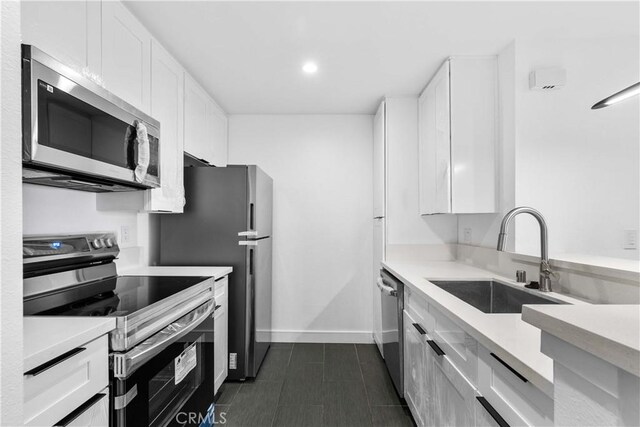 kitchen featuring sink, stainless steel appliances, and white cabinetry