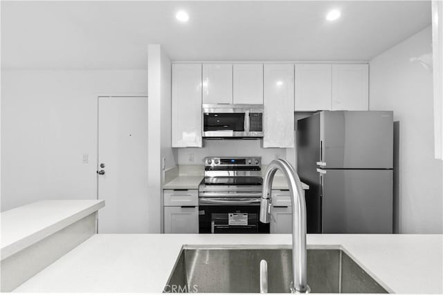 kitchen featuring white cabinetry, stainless steel appliances, and sink