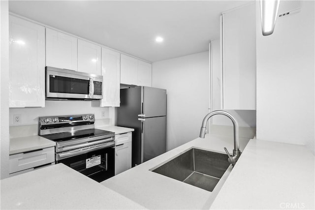 kitchen featuring sink, white cabinetry, and appliances with stainless steel finishes