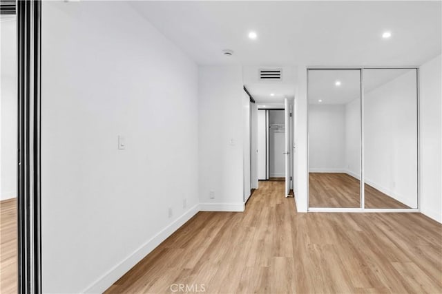 unfurnished bedroom featuring light wood-type flooring and a closet