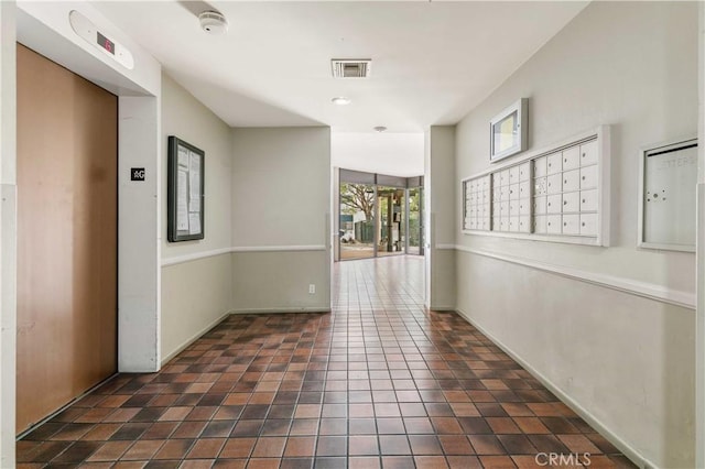 hallway with a mail area and elevator