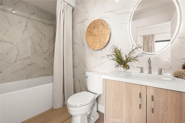 full bathroom featuring toilet, vanity, tile walls, hardwood / wood-style floors, and shower / tub combo