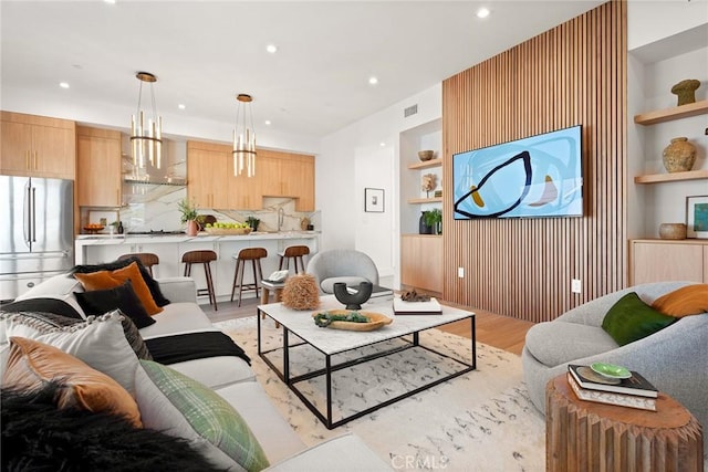 living room with light hardwood / wood-style floors and built in features