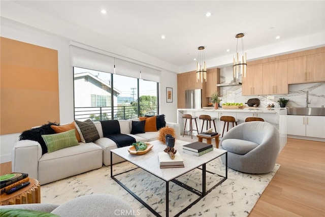 living room with sink and light hardwood / wood-style flooring