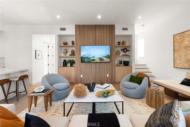 living room featuring light hardwood / wood-style flooring and built in shelves