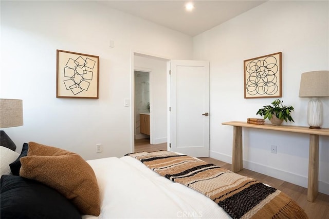 bedroom featuring light wood-type flooring and ensuite bath