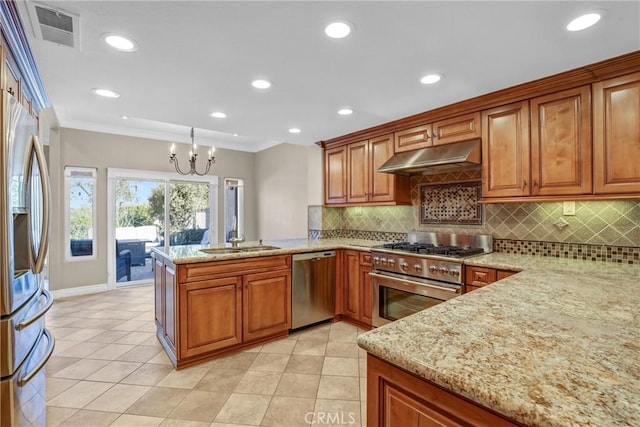 kitchen with visible vents, under cabinet range hood, a peninsula, brown cabinetry, and stainless steel appliances