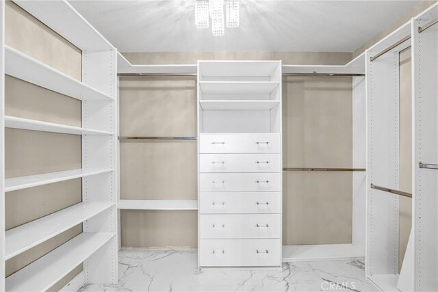 walk in closet featuring marble finish floor