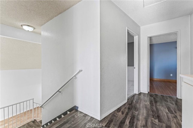 hallway featuring a textured ceiling and dark hardwood / wood-style flooring