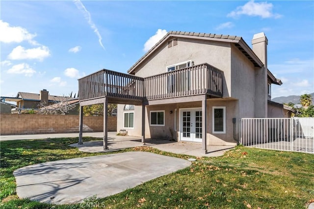 back of house with french doors, a patio area, and a yard