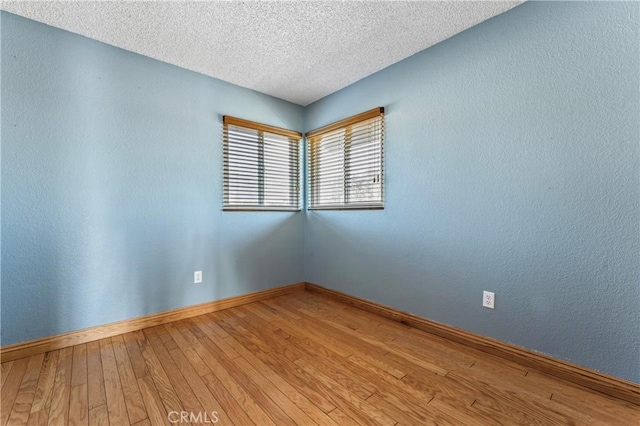 spare room featuring a textured ceiling and hardwood / wood-style floors