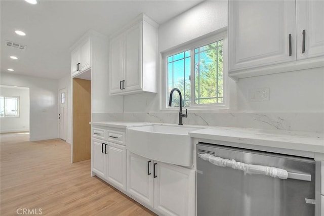 kitchen with dishwasher, a wealth of natural light, sink, white cabinetry, and light hardwood / wood-style flooring