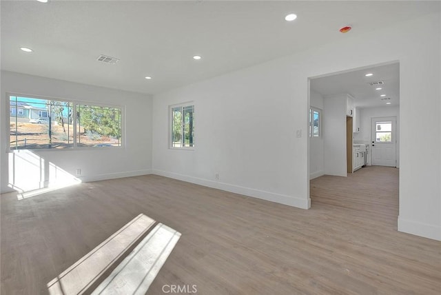 empty room featuring light wood-type flooring and plenty of natural light