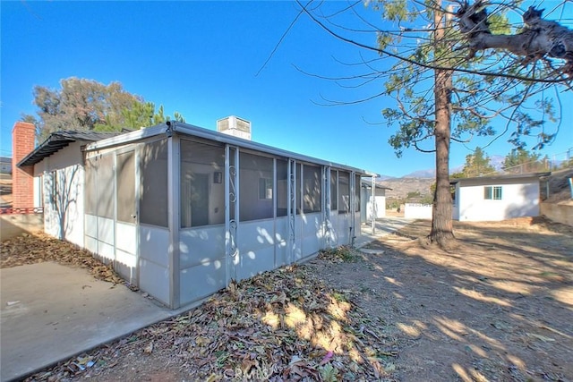 view of property exterior featuring a sunroom