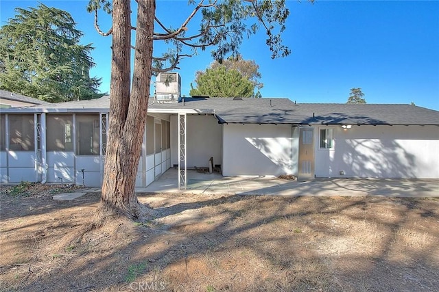 back of property with a patio area and a sunroom