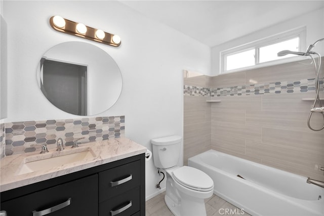 full bathroom with toilet, vanity, decorative backsplash, and tiled shower / bath