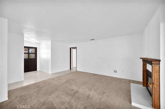 unfurnished living room featuring light carpet