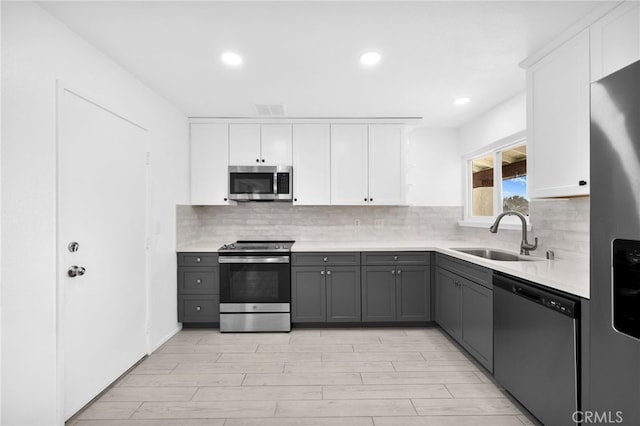 kitchen featuring white cabinets, sink, gray cabinets, and stainless steel appliances