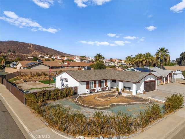 ranch-style home with a garage and a mountain view