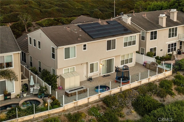 2438 Calle Aquamarina, San Clemente, CA 92673 - rear view of house featuring a fenced backyard, solar panels, stucco siding, and a chimney