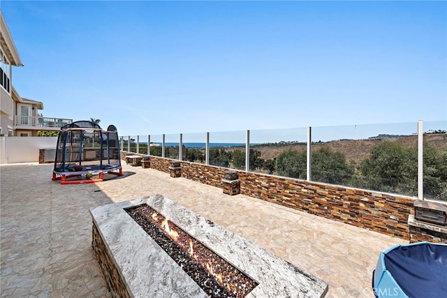 view of patio featuring an outdoor fire pit and a trampoline