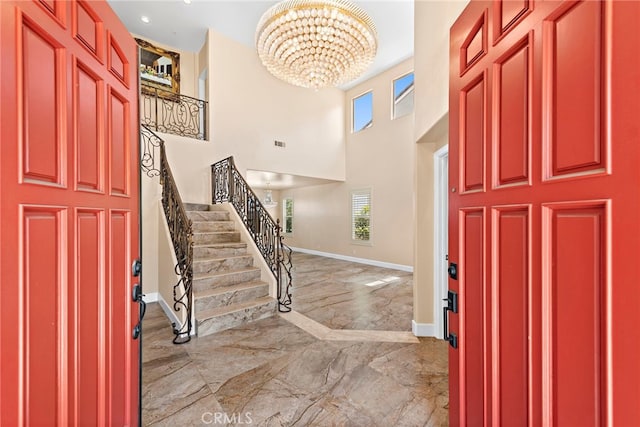 foyer entrance with a towering ceiling and a chandelier